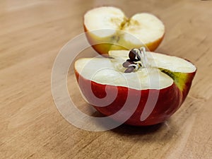 Halves of a red apple. Seeds began to germinate in the body of the apple. Close-up.