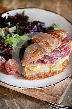 Ham, cheddar cheese and scrumbled egg stuffed French croissant, close-up