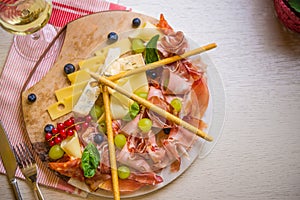 Ham, cheese, baked potatoes, olives and olives with wine. Snack dinner table concept top view