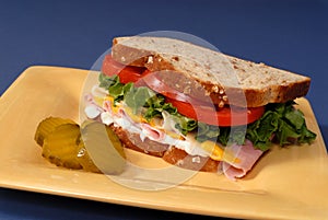 Ham, cheese, lettuce and tomato sandwich with pickles