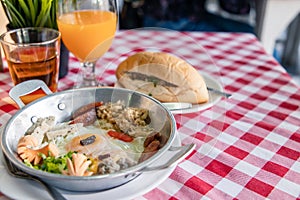 Ham and cheese omelet in a pan with fresh vegetables