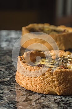 ham and cheese quiche with oregano on a marble counter with selective focus