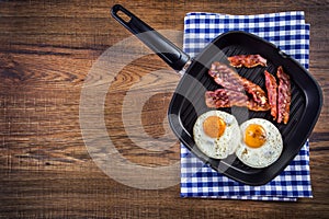 Ham and Egg. Bacon and Egg. Salted egg and sprinkled with black pepper. Grilled bacon, two eggs in a Teflon pan photo