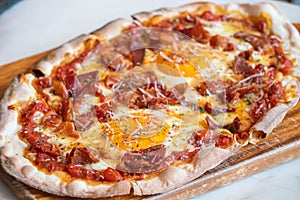 Ham and Eggs Breakfast style pizza on wooden platter