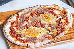 Ham and Eggs Breakfast style pizza on wooden platter