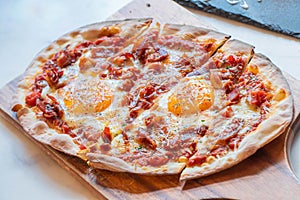 Ham and Eggs Breakfast style pizza on wooden platter