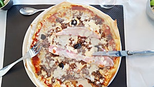 Ham pizza in restaurant with knife and fork