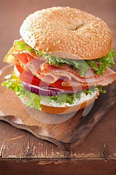 Ham sandwich on bagel with cream cheese tomato onion