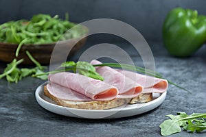 Ham sandwich. Pork ham slices over wholegrai bread over dark background