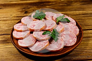 Ham sausage on a plate on wooden table