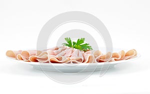 Ham sliced and arranged, served on a plate with parsley