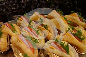 Ham, tomato and vegetable croissant sandwiches served in foil on a dish