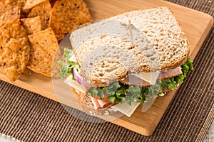 Ham Turkey Sandwich For Lunch With Chips On Wood Board