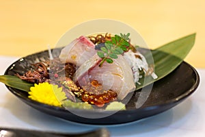 Hamachi Sashimi and Hotaru-ika on black plate