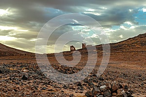 Hamada du Draa, moroccan stone desert in foreground, mountains in background, Morocco