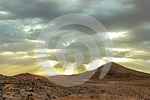 Hamada du Draa, moroccan stone desert in foreground, mountains in background, Morocco