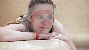 Hamam, family in the Turkish sauna, a young girl lying on the bench. Close-up of her face.