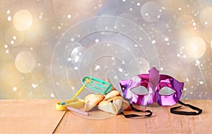 Hamantaschen cookies or hamans ears,noisemaker and mask for Purim celebration (jewish holiday) and glitter background