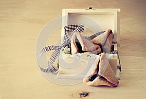 Hamantaschen cookies or hamans ears for Purim celebration in wooden box. vintage effect.