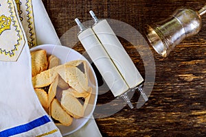 Hamantaschen cookies and masks on wood desk background. Purim holiday kippah tallit