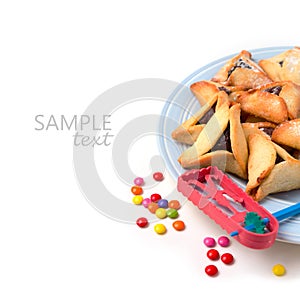 Hamantaschen cookies on plate and grogger on white background