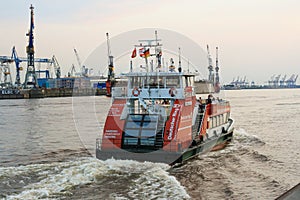 Passenger ferry sightseeing tour boat leaving from St. Pauli`s Piers or LandungsbrÃÂ¼cken with Blohm and Voss shipyards in backgrou