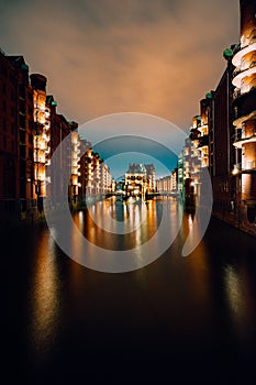 Hamburg, Germany. View of Wandrahmsfleet at dusk illumination light with clouds above. Located in Warehouse District - photo