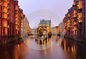 Hamburg`s Speicherstadt while evening with illuminated balcony