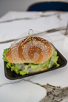 a hamburger in a black plate on the table