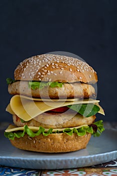 Hamburger bun, double chicken cutlet with cheese, lettuce, arugula and radish. Meat, vegetables and bread. Ingredients. Homemade