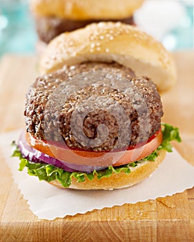 Hamburger with bun off to side, sitting on wax pap