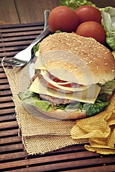 Hamburger with cheese, tomato, onion and lettuce