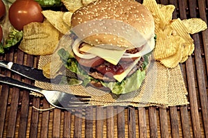 Hamburger with cheese, tomato, onion and lettuce