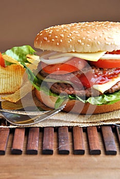 Hamburger with cheese, tomato, onion and lettuce