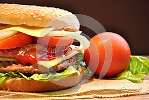 Hamburger with cheese, tomato, onion and lettuce