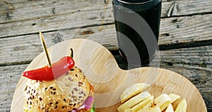 Hamburger, french fries and cold drink on wooden board