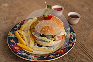 Hamburger with french fries in plate with ornaments