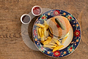 Hamburger with french fries in plate with ornaments