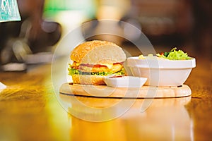 Hamburger and french fries and tomato sauce on wooden board. Fast food concept. Burger with cheese meat and salad. Cheat