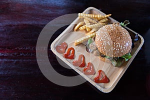 Hamburger with french fries in wooden plate