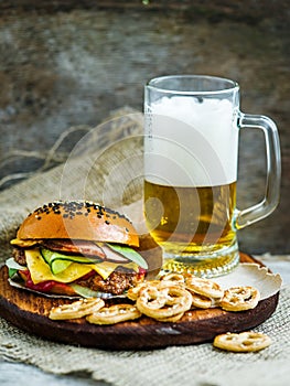 Hamburger with glass of beer and marinated cucumbers
