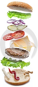 Hamburger ingredients falling down one by one to create a perfect meal. Colorful conceptual picture of burger cooking. Clipping