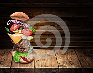 Hamburger ingredients falling down one by one to create a perfect meal. Colorful conceptual picture of burger cooking