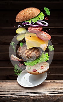 Hamburger ingredients falling down one by one to create a perfect meal. Colorful conceptual picture of burger cooking