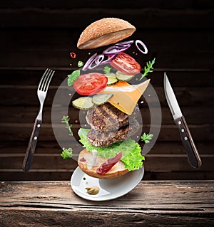 Hamburger ingredients falling down one by one to create a perfect meal. Colorful conceptual picture of burger cooking