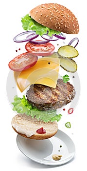 Hamburger ingredients falling down one by one to create a perfect meal. Colorful conceptual picture of burger cooking. Clipping