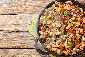 Hamburger Macaroni with with vegetables and cheese closeup in the pan. Horizontal top view