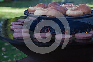 Hamburger meat and buns are grilled on the grill. Outside cooking and barbeque. Meal on the grill. Hamburger patties grilling outd