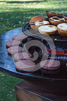 Hamburger meat and buns are grilled on the grill. Outside cooking and barbeque. Meal on the grill. Hamburger patties grilling outd