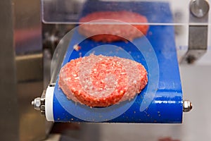 Hamburger meat on conveyor belt